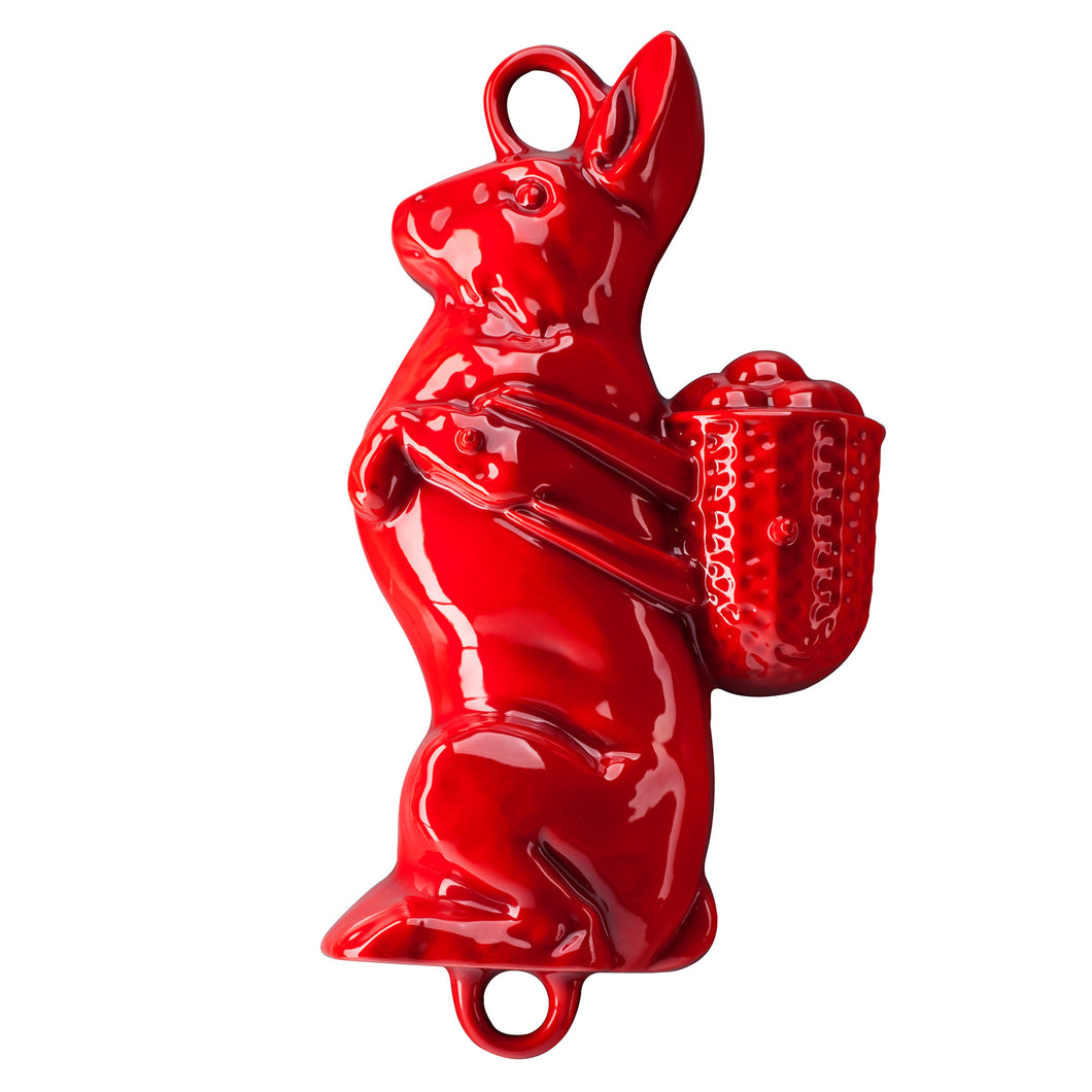 Eine Backform aus Gusseisen für einen Osterhasen. Der Hase trägt eine prall gefüllten Eierkorb auf dem Rücken. Die Backform ist von Gourmetina. Die Innenseite ist weiß emailliert. Die Außenseite ist farbig emailliert.